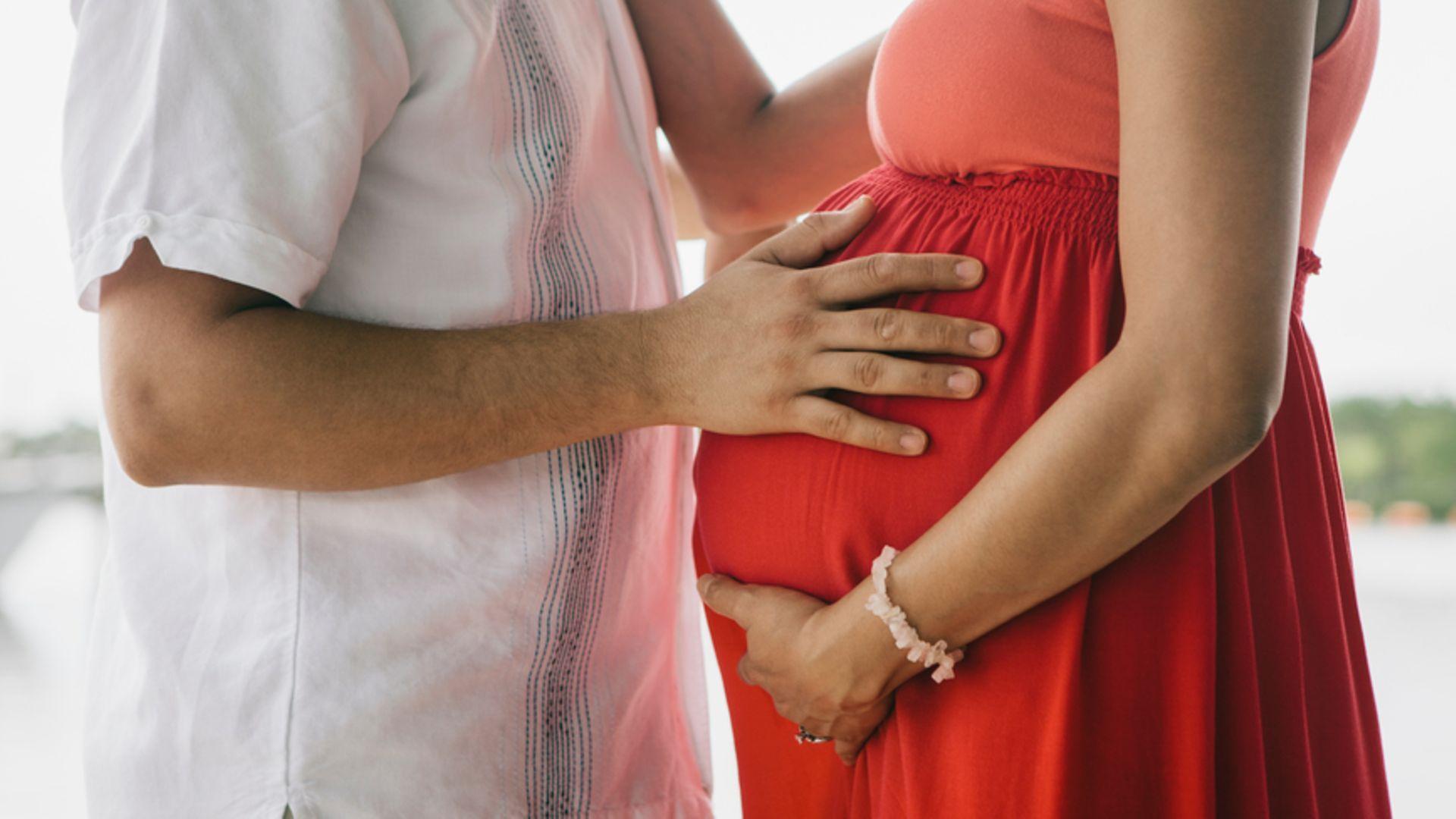 Risikoschwangerschaft: Paar umfasst schwangeren Bauch der Frau