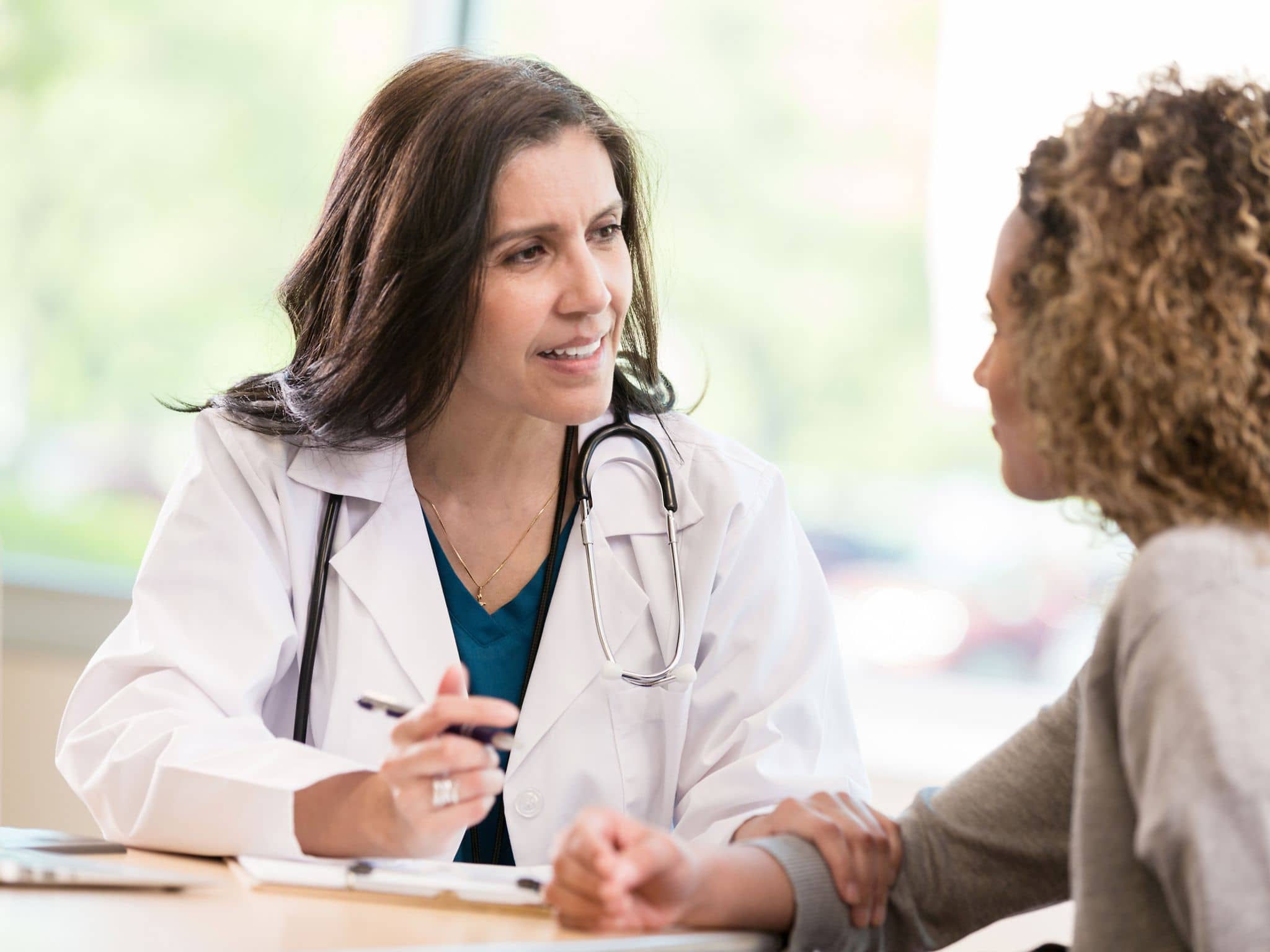 Vorbereitung Besuch bei Frauenärztin: Eine Gynäkologin im Gespräch mit einer Patientin