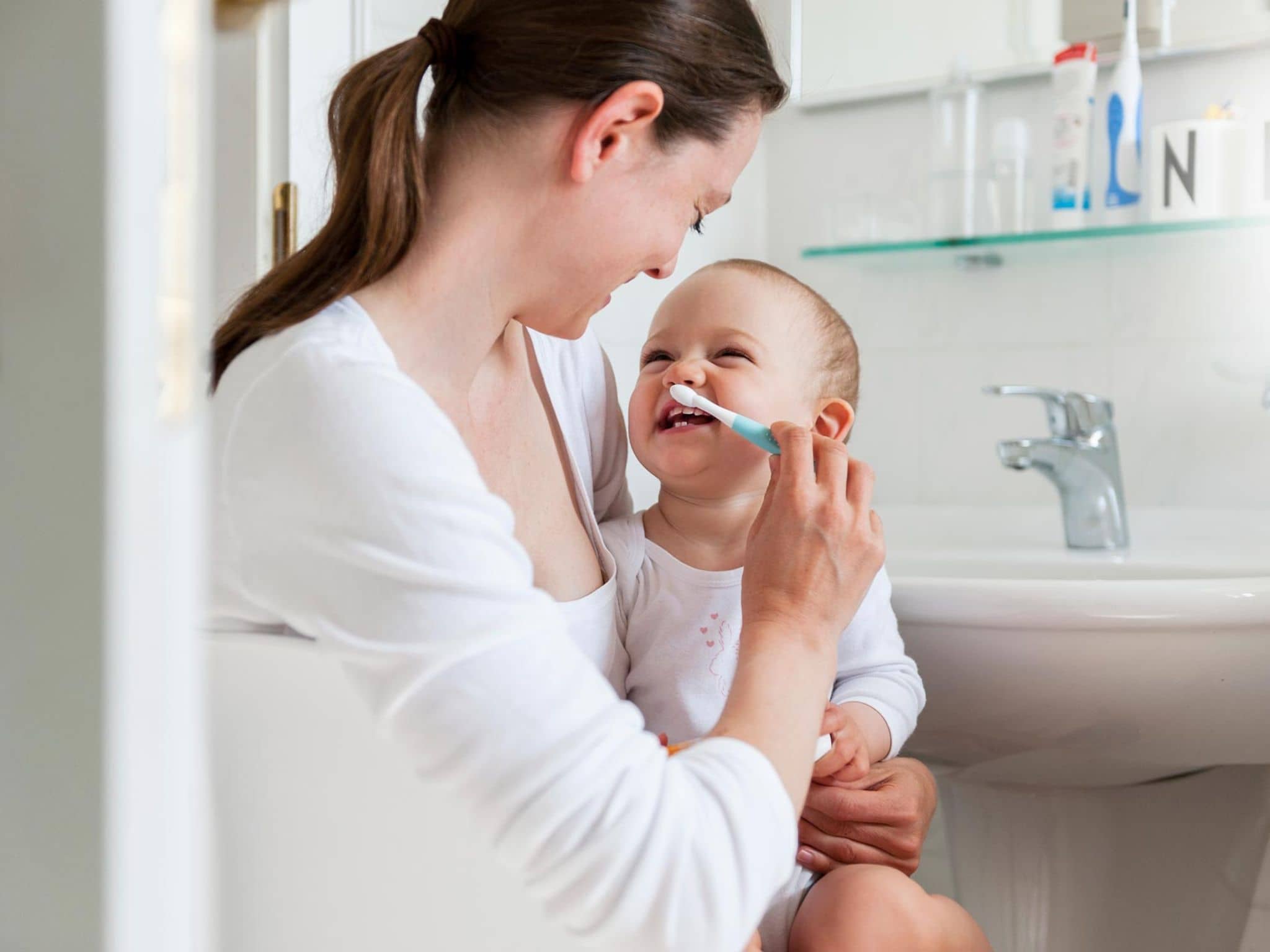 Zahnpflege bei Babys: Eine Mutter putzt die Zähne ihres Kleinkinds.