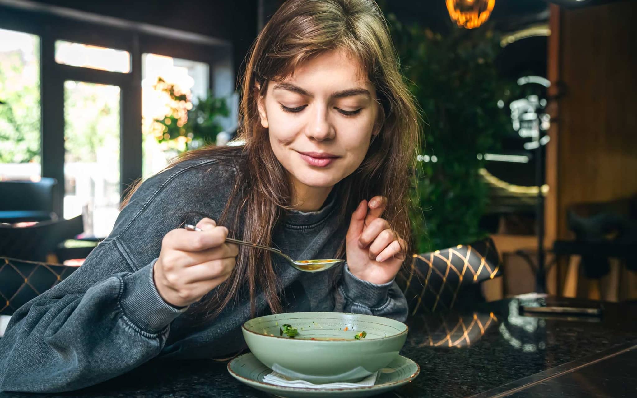 Junge Frau isst einen Bohneneintopf