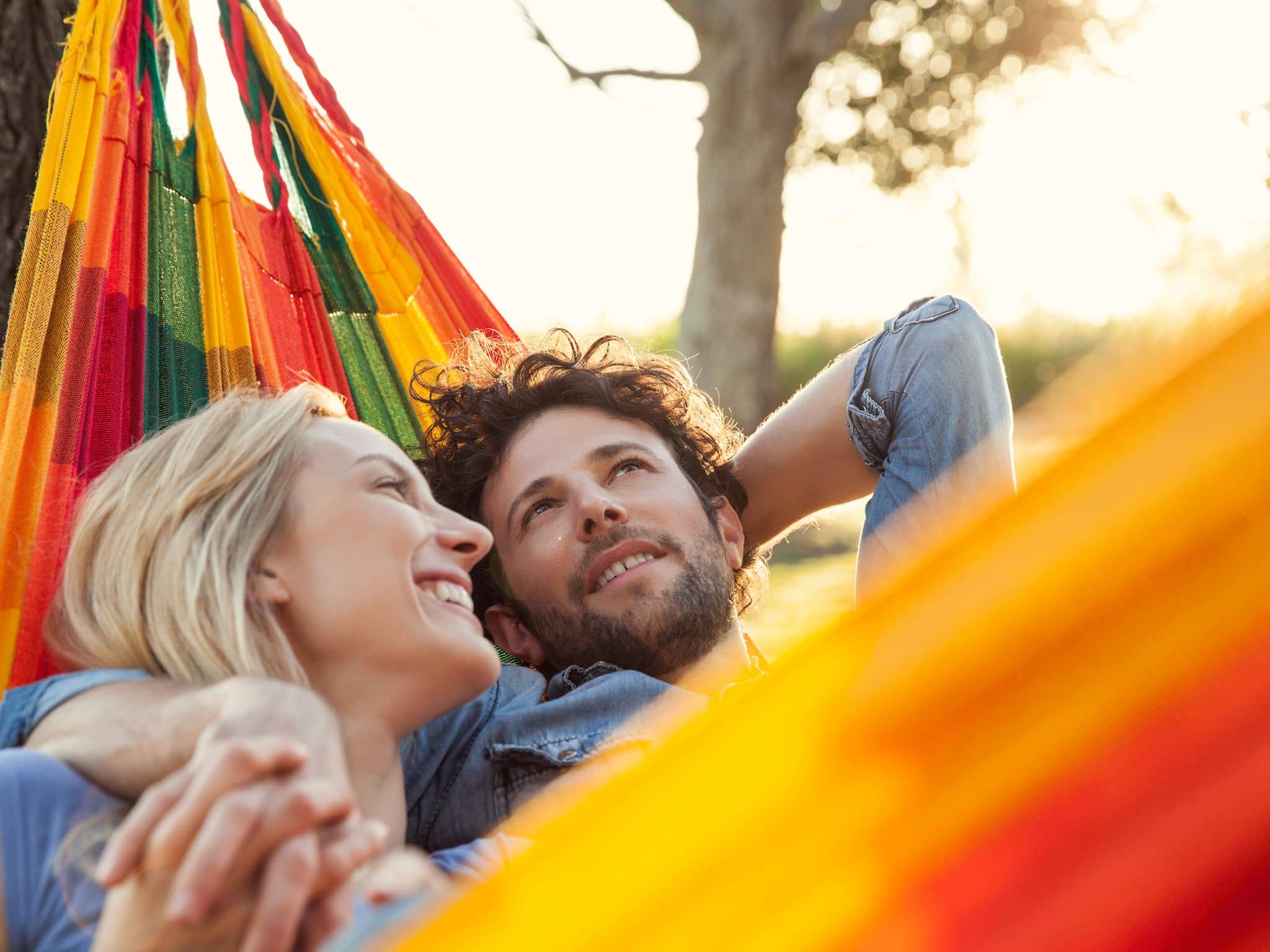 Rebound-Beziehung: Ein verliebtes Paar liegt schmusend in einer Hängematte
