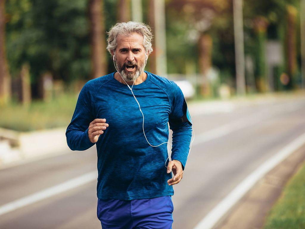 Sportmedizinische Untersuchung: Älterer Mann joggt Straße entlang
