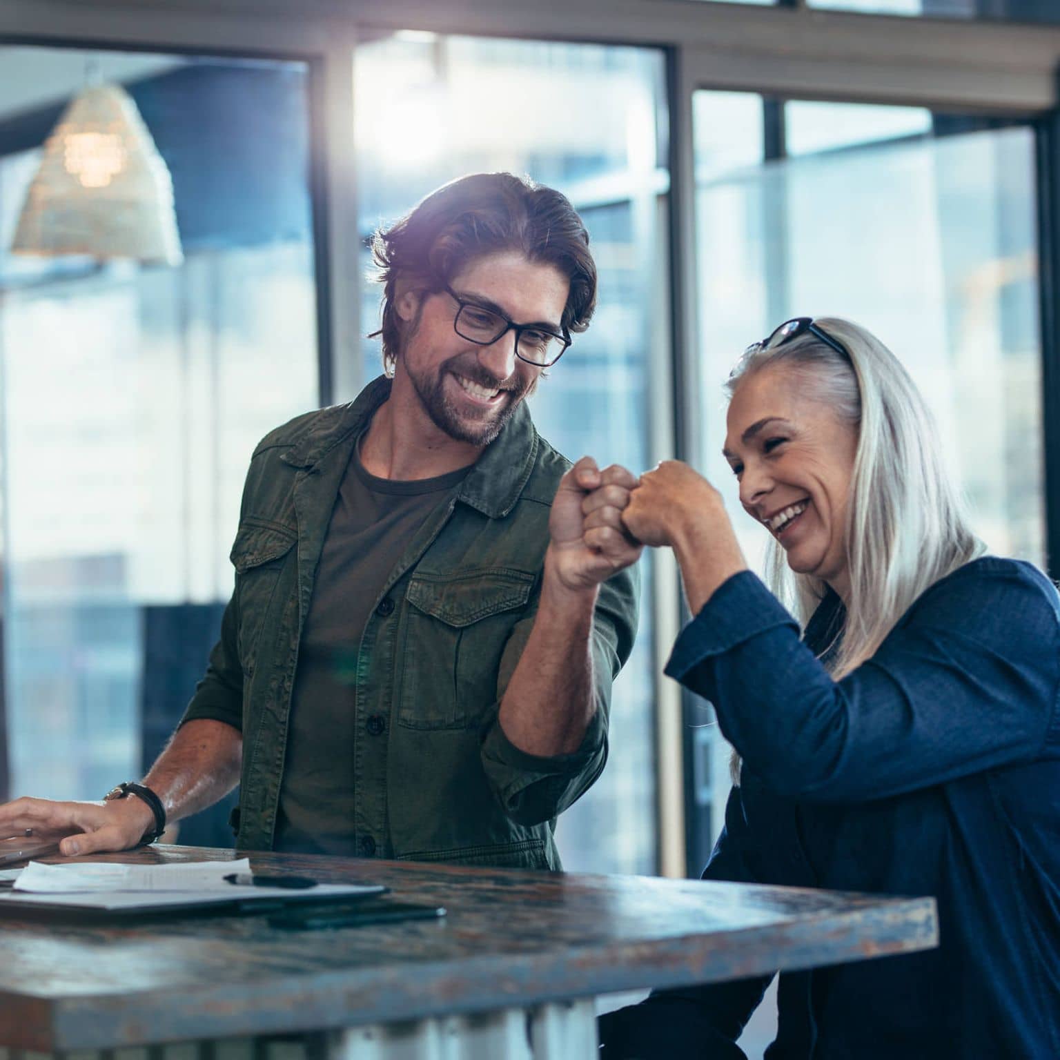 Bild: Kollege und Kollegin machen eine Faust und sehen zufrieden aus.