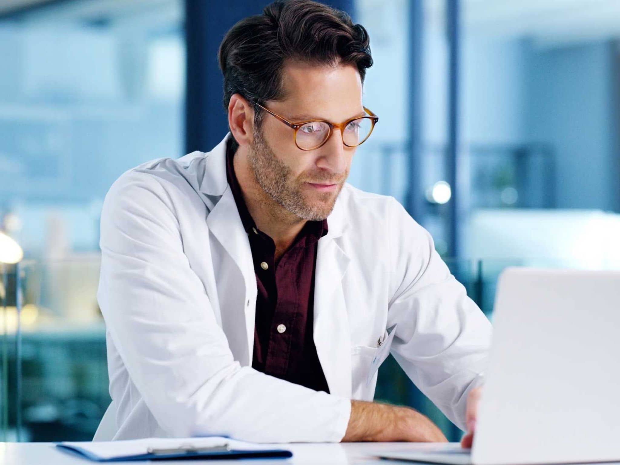 Kommunikation im Medizinwesen (KIM): Arzt sitzt vor Computer