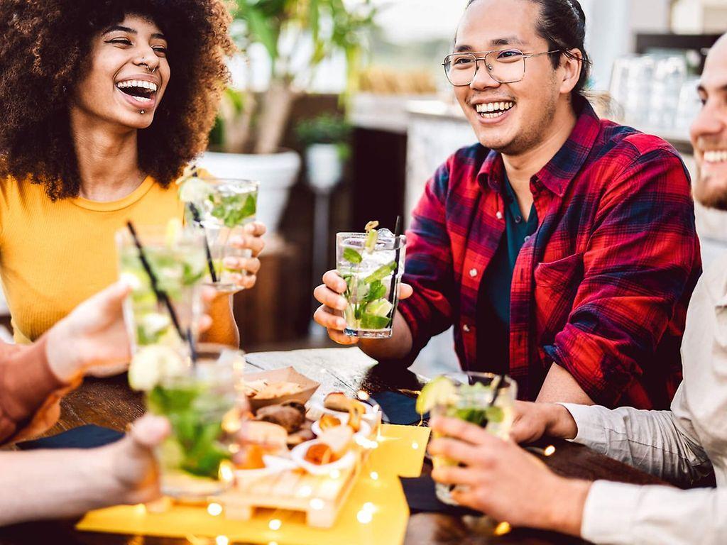 Alkoholfrei leben: Junge Leute sitzen zusammen und trinken alkoholfreie Mocktails.