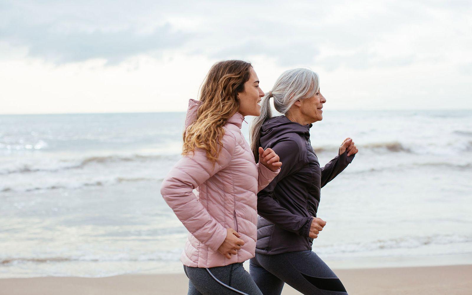 Ausdauertraining: Zwei Frauen joggen am Strand.