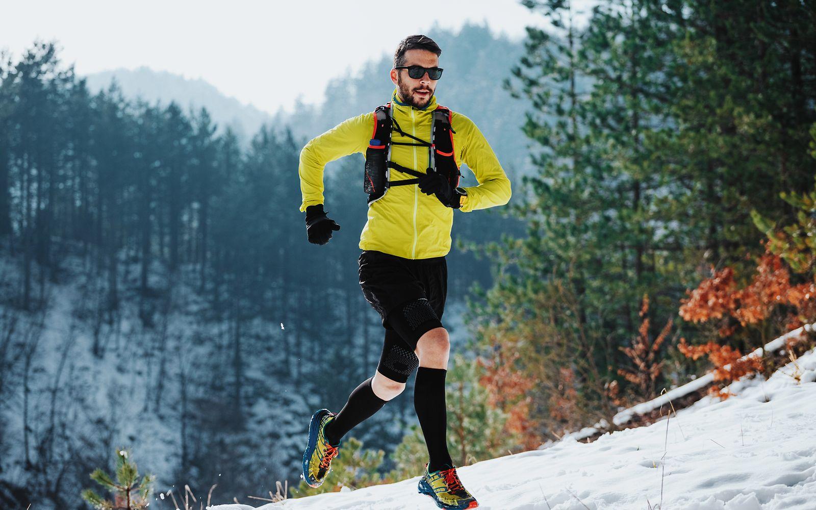 Sport im Winter: Ein Läufer auf einem verschneiten Trail in den Bergen