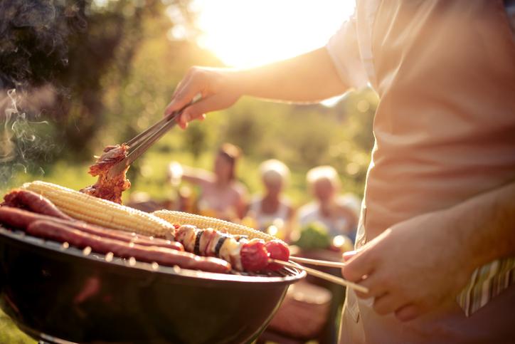 Fehler beim Grillen: Ein Mann wendet beim Grille ein Stück Fleisch 