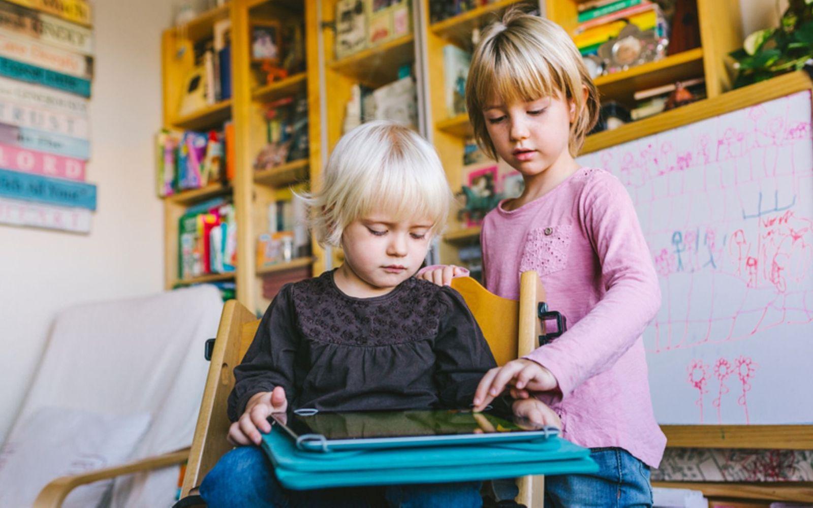 Kinder und Medien: Zwei kleine Kinder spielen mit dem Tablet