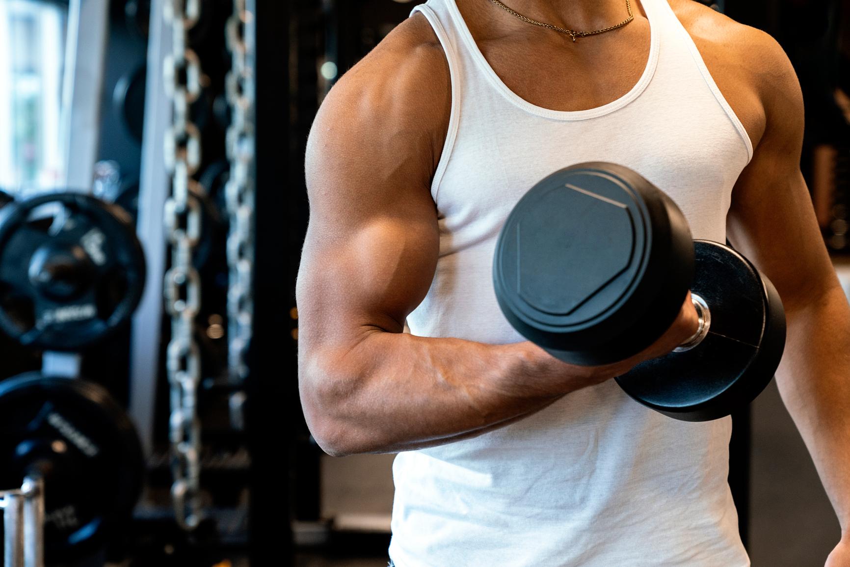 Mann trainiert im Fitnessstudio mit Kurzhantel