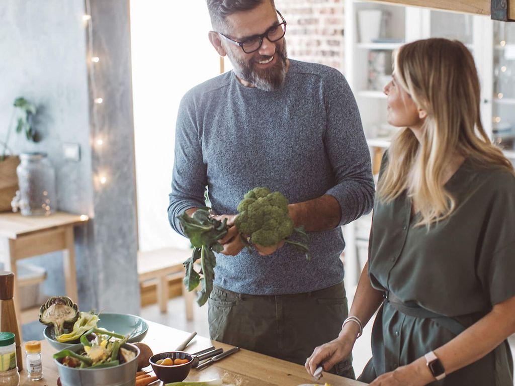 Ernährungstipps: Junges Paar kocht mit Spaß und frischen Zutaten