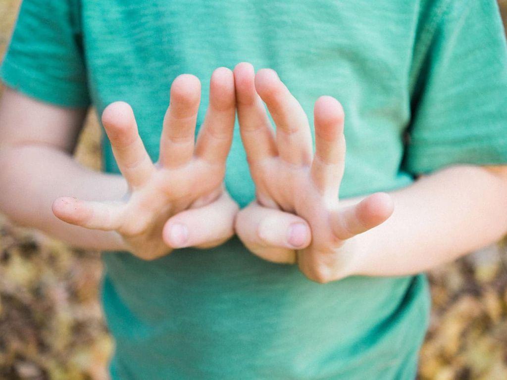 U11 Untersuchung: Ein Junge im grünen T-Shirt hält acht Finger ins Bild.