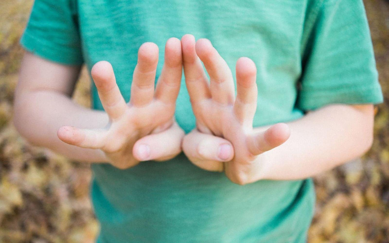 U11 Untersuchung: Ein Junge im grünen T-Shirt hält acht Finger ins Bild.