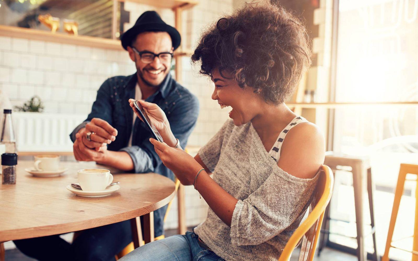 Gesundheitsuntersuchung: Zwei Freunde sitzen fröhlich zusammen im Café