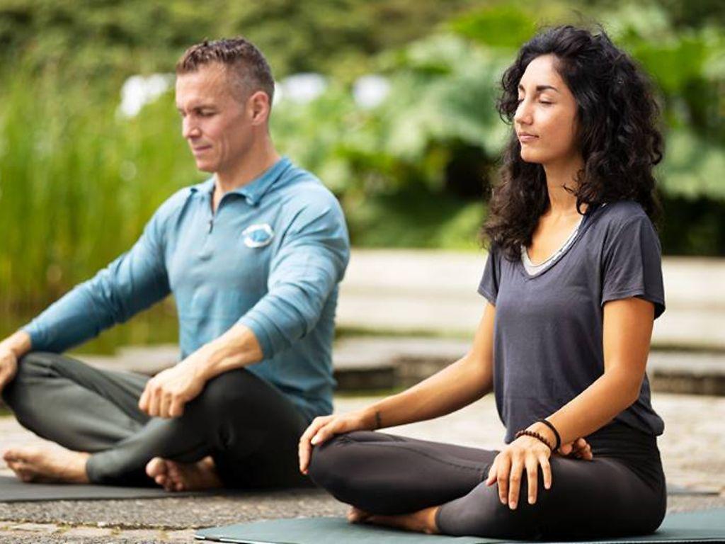 Patric Heizmann mit Yogalehrerin Sara Lyn im Yogasitz