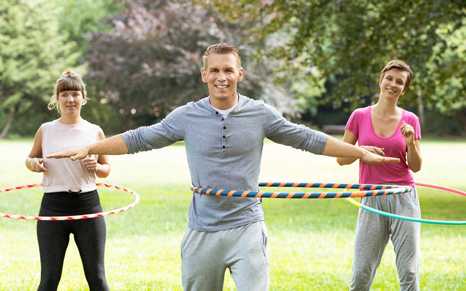 Hula Hoop: Patric Heizmann trainiert gemeinsam mit zwei Frauen im Park