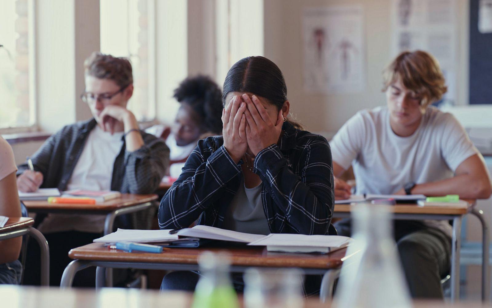 Bild: Präventionsradar 2023: Schulkind sitzt verzweifelt im Klassenraum.