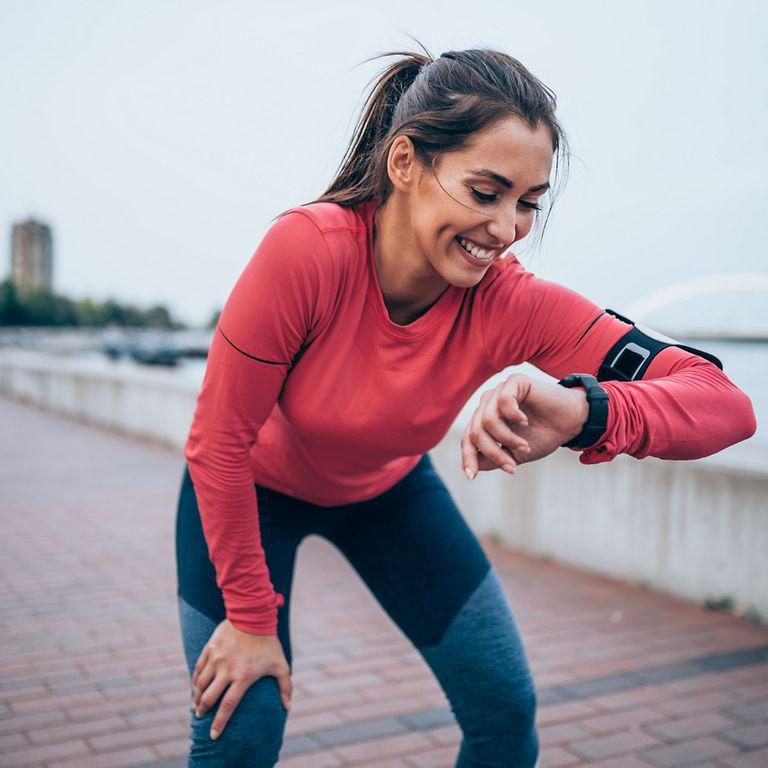 Bild: Läuferin schaut auf ihre Smartwatch als Teil der DAK GroupFitness-Challenge.