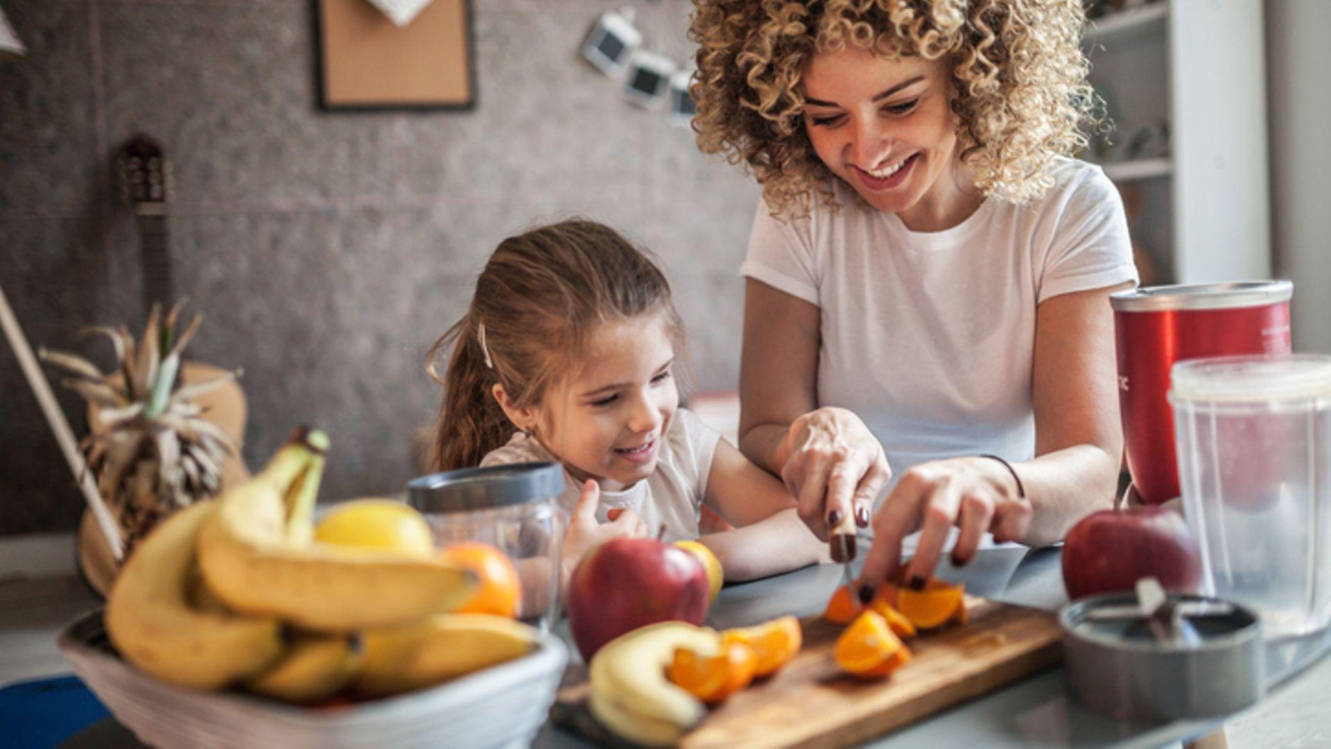 Essen und Trinken: Mutter und Tochter machen Smoothie