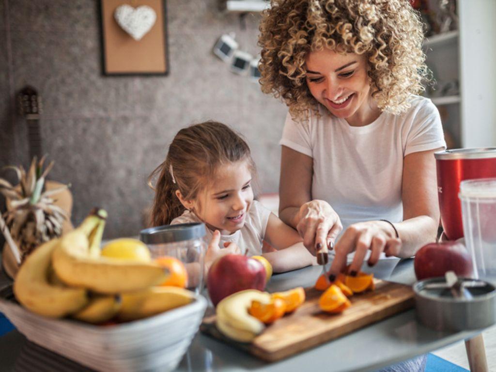 Essen und Trinken: Mutter und Tochter machen Smoothie