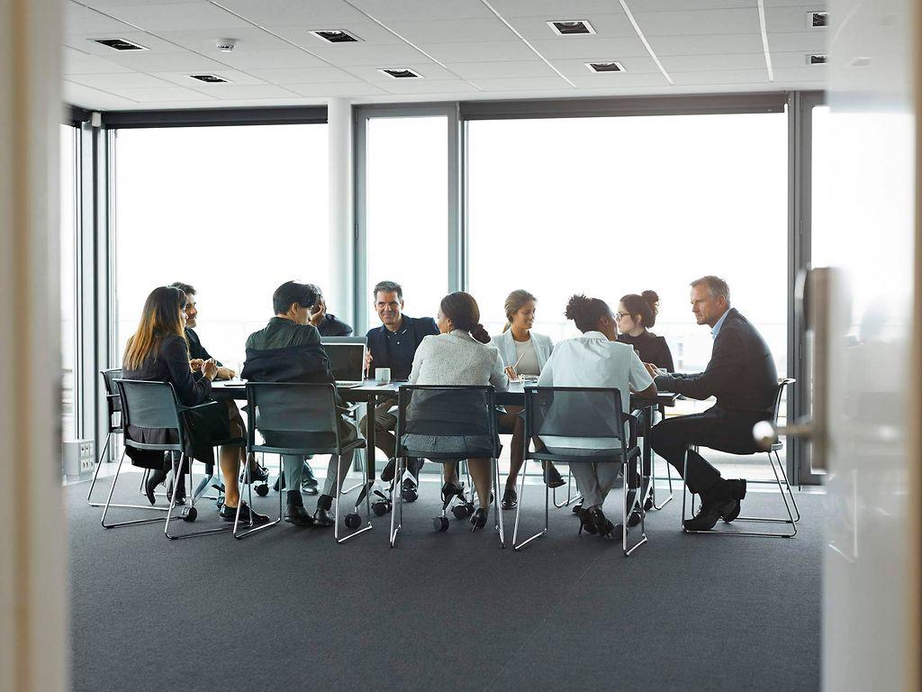 Bild: Symbolbild Menschen sitzen an einem Konferenztisch