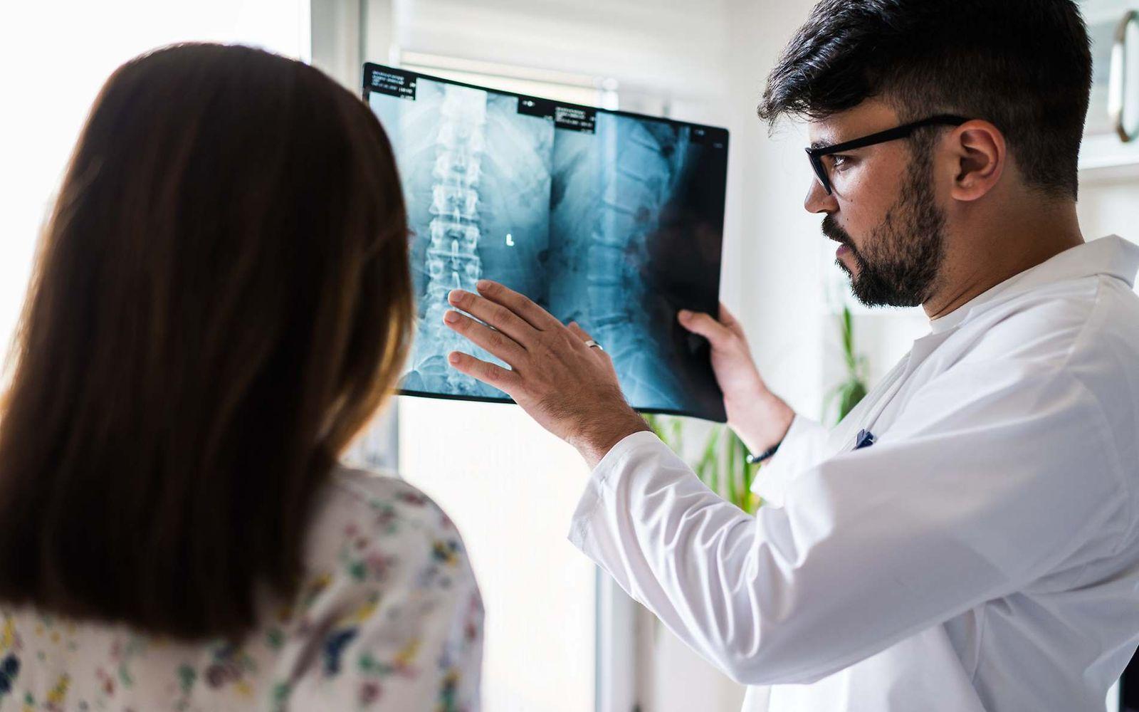 Bild: Arzt erklärt einer Patientin etwas zu ihrem Röntgenbild der Wirbelsäule.