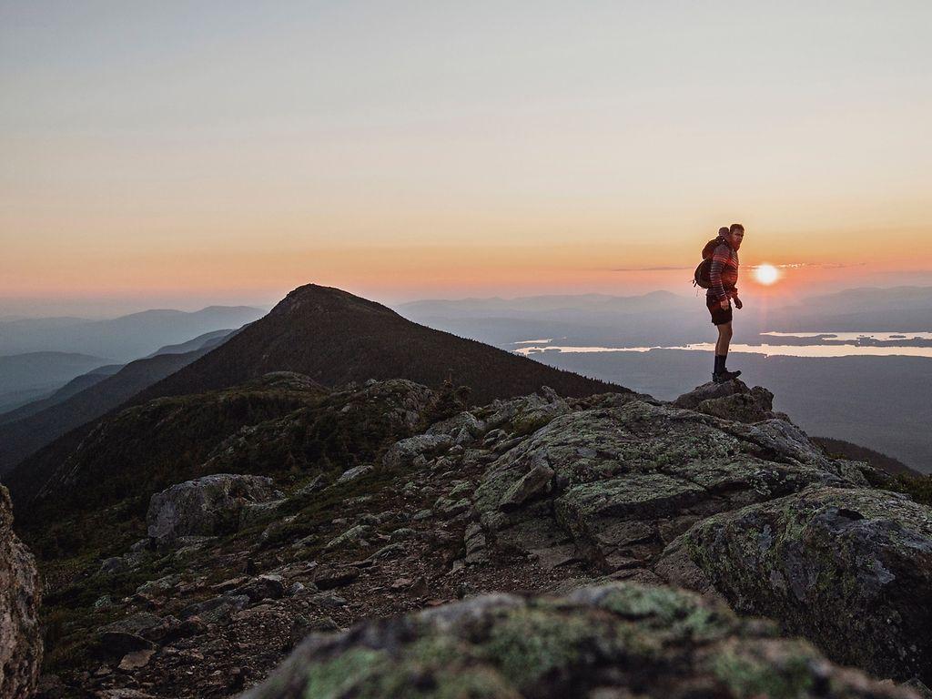 Sabbatical: Mann steht bei Sonnenuntergang auf einem Berg