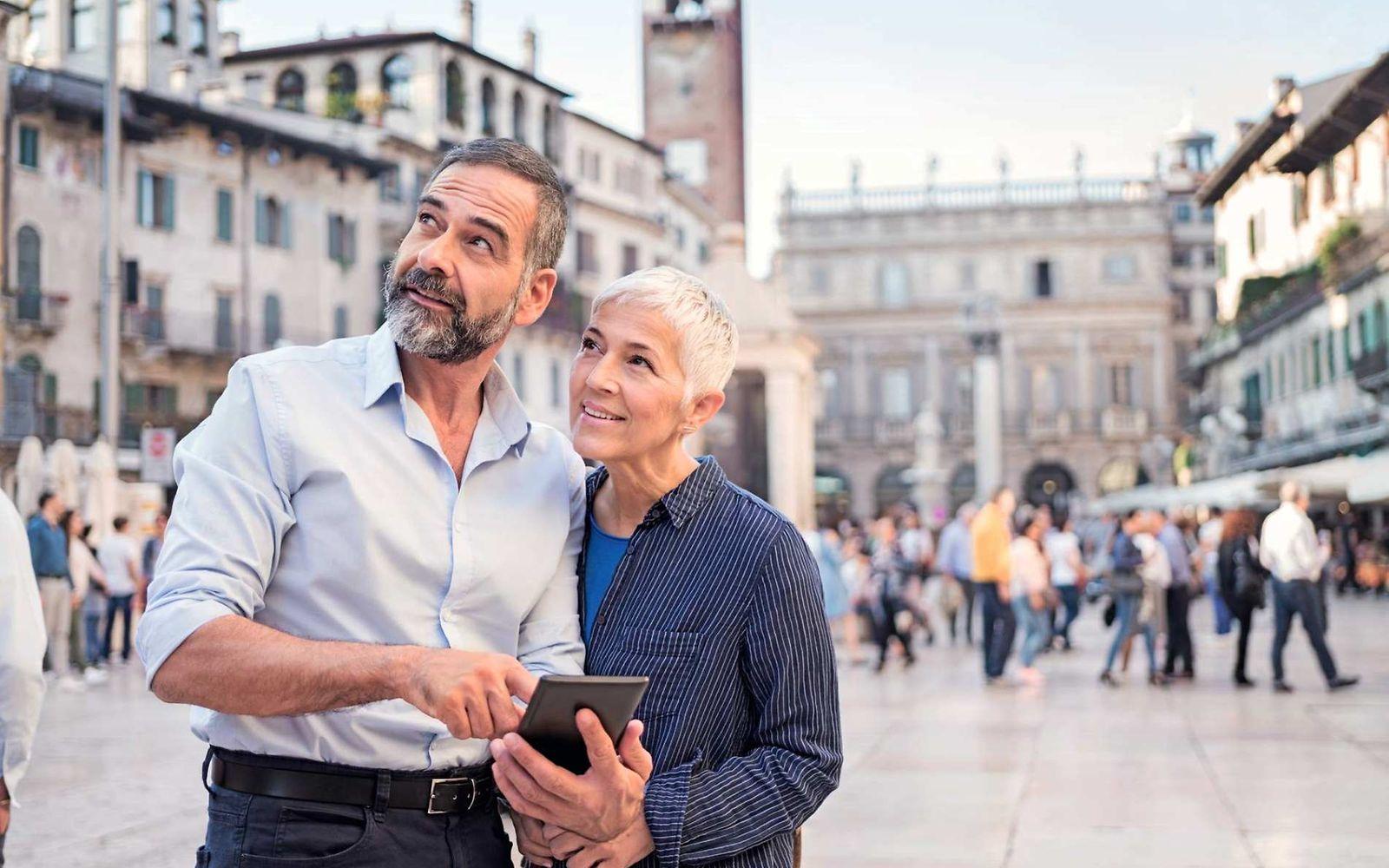 Bild: Älteres Paar auf Reisen schaut etwas im Handy nach.