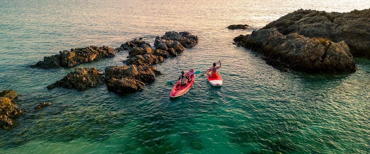 Reiseschutzimpfung: Zwei Frauen auf einem Kajak und Paddleboard