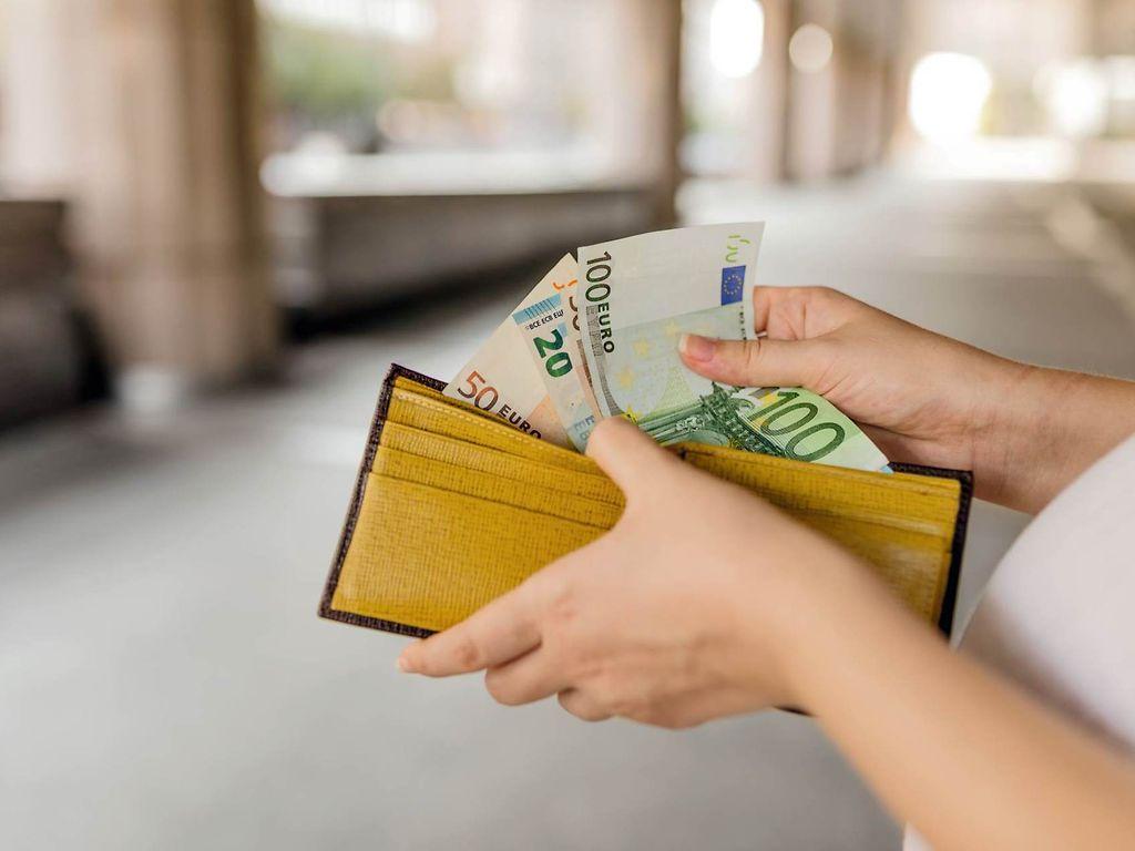 Bild: Frau prüft Geld in ihrem Portemonaie