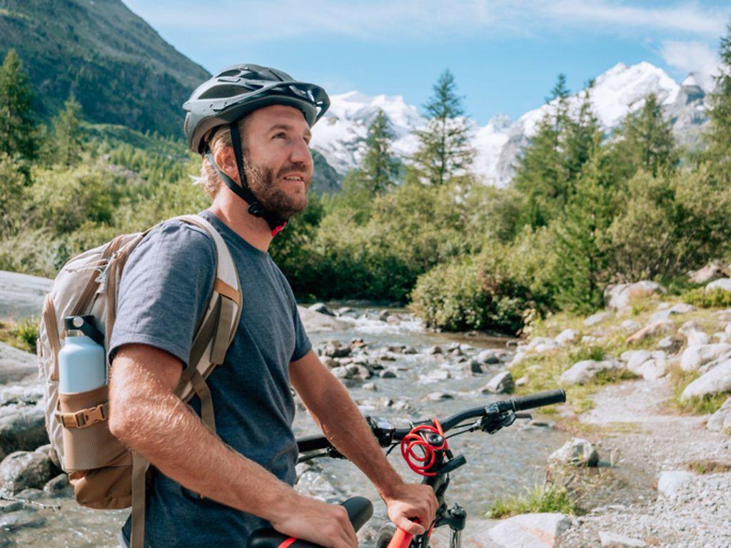 Symbolbild ein Mann mit Fahrrad in den Bergen