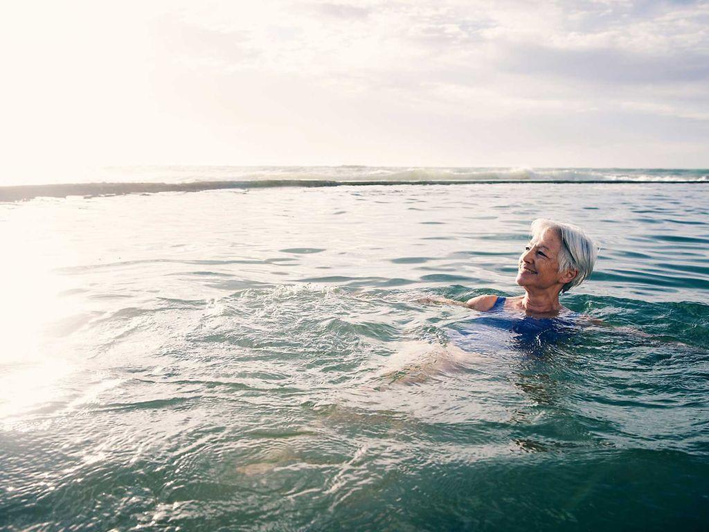 KHK und Sport: Ältere Frau schwimmt in einem See