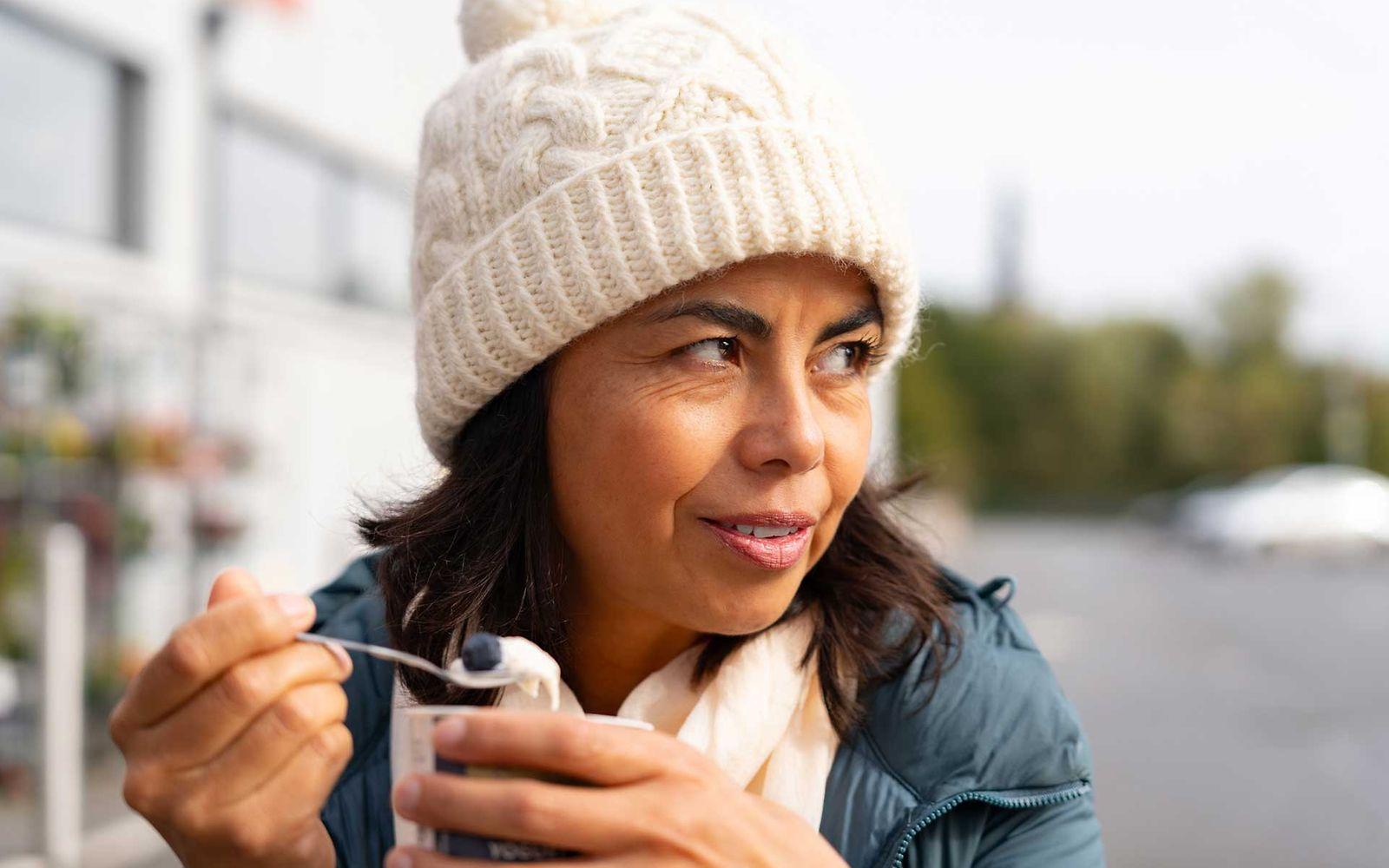 Ernährung bei Osteoporose: Frau isst Joghurt