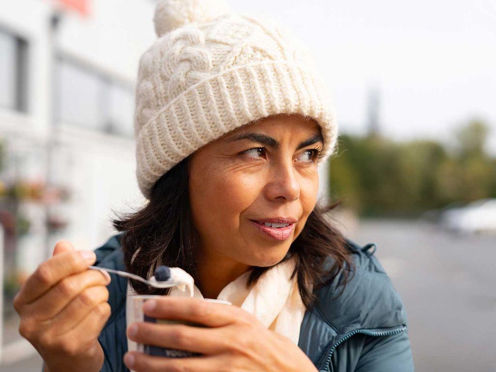 Ernährung bei Osteoporose: Frau isst Joghurt