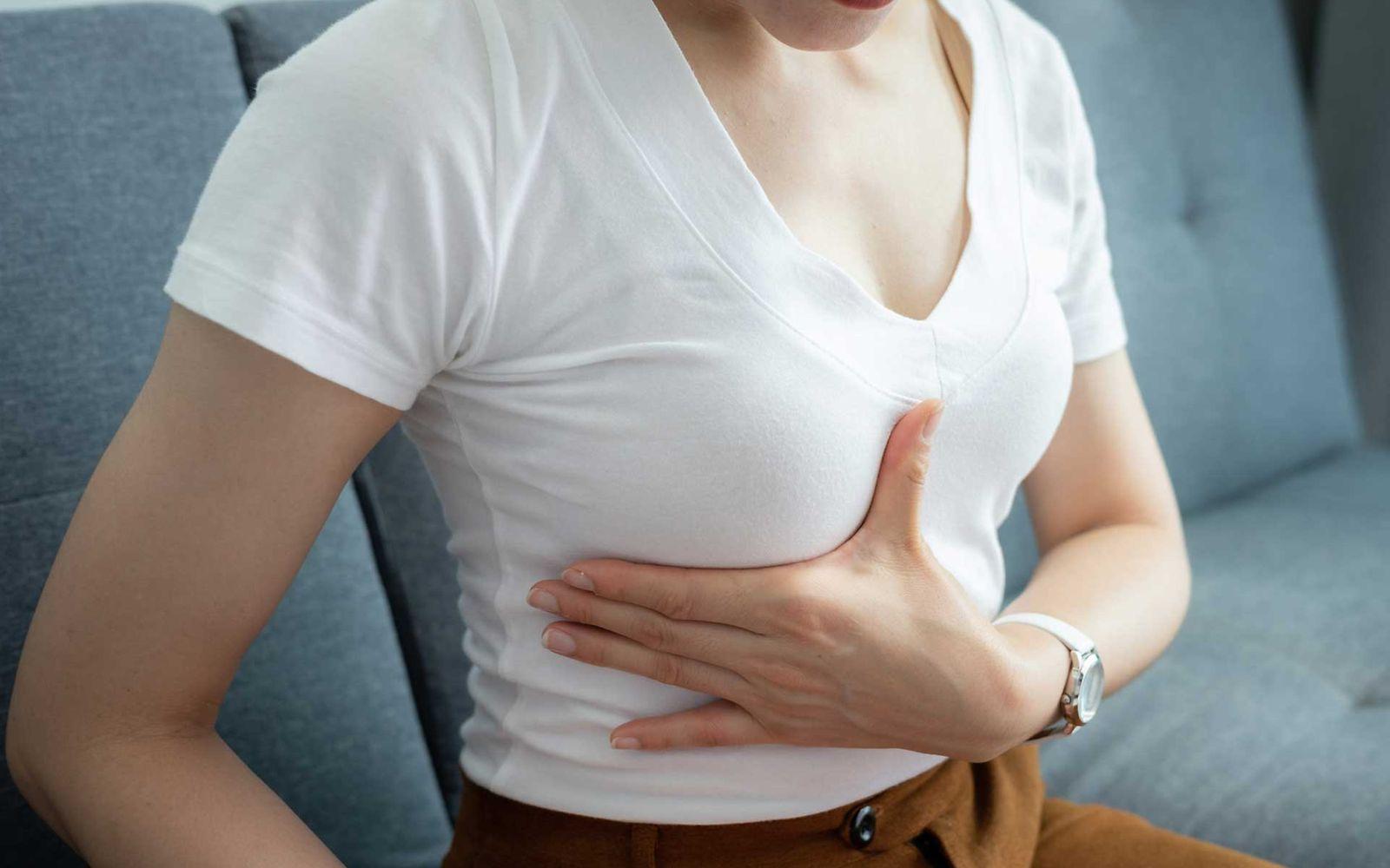 Symbolbild Brustkrebs-OP: Frau tastest ihre Brust ab