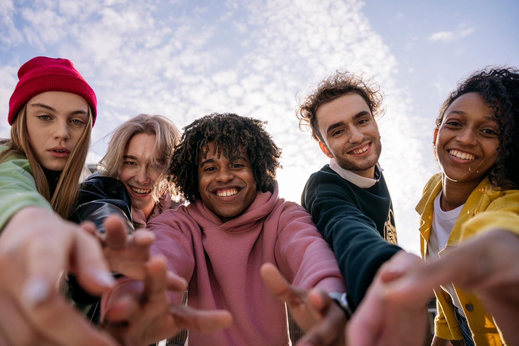 A group of students from different cultures take selfies.