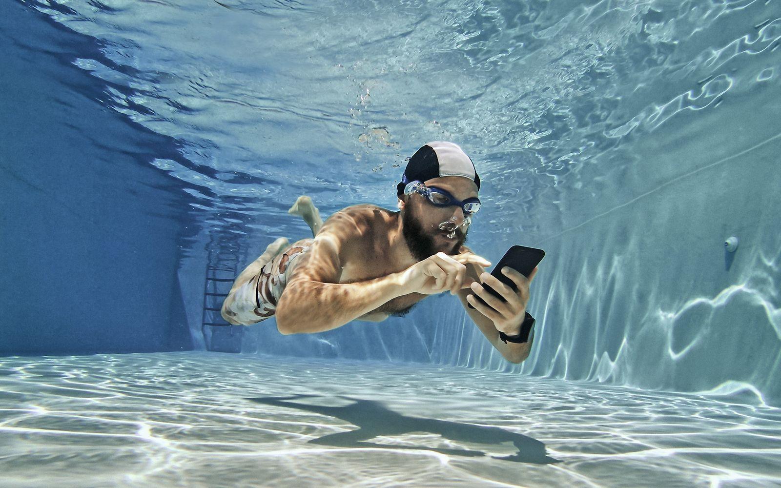 Schwimmer mit Handy unter Wasser