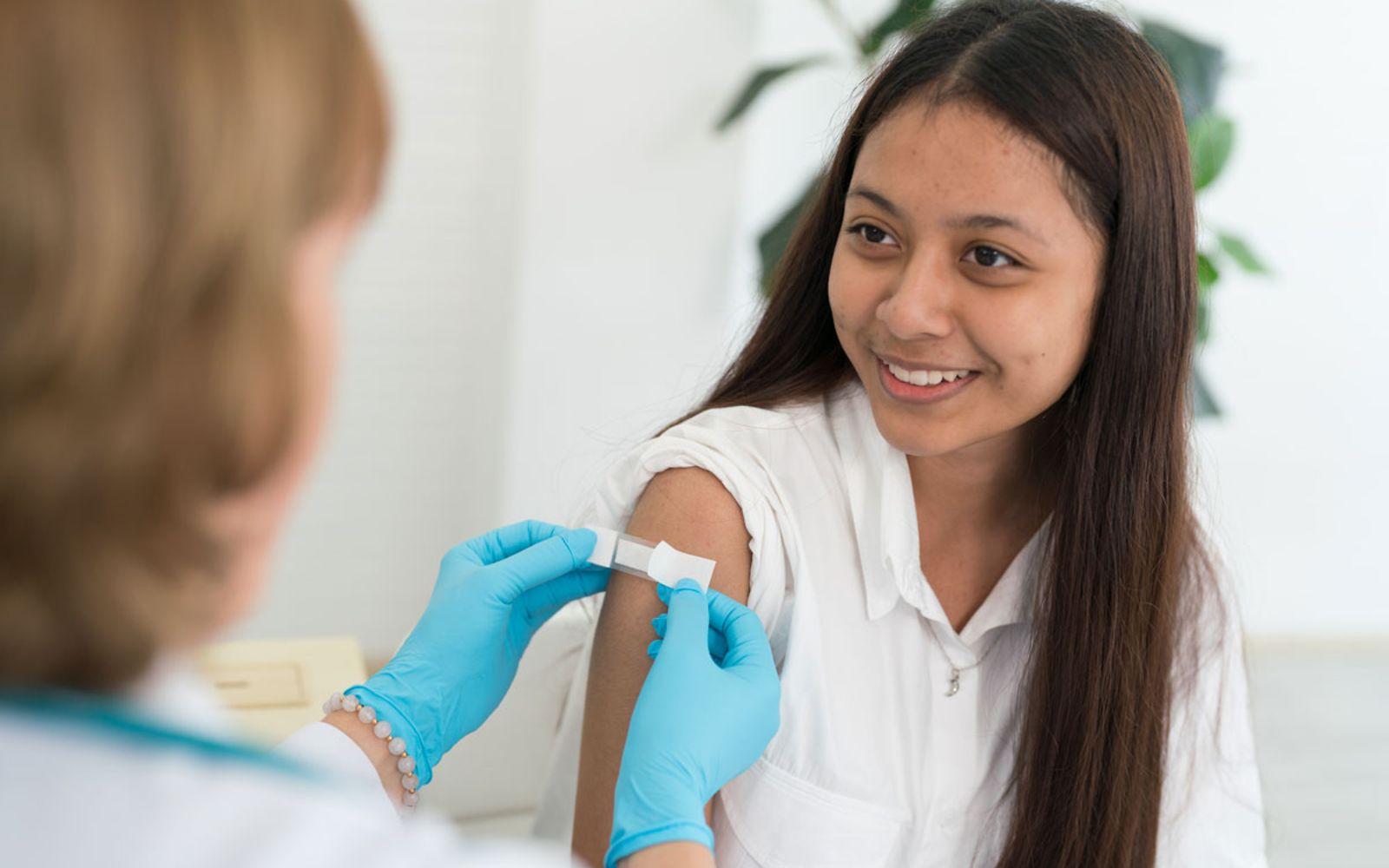 Schutz vor schweren Krankheiten durch HPV-Impfung: Ärztin impft Mädchen.