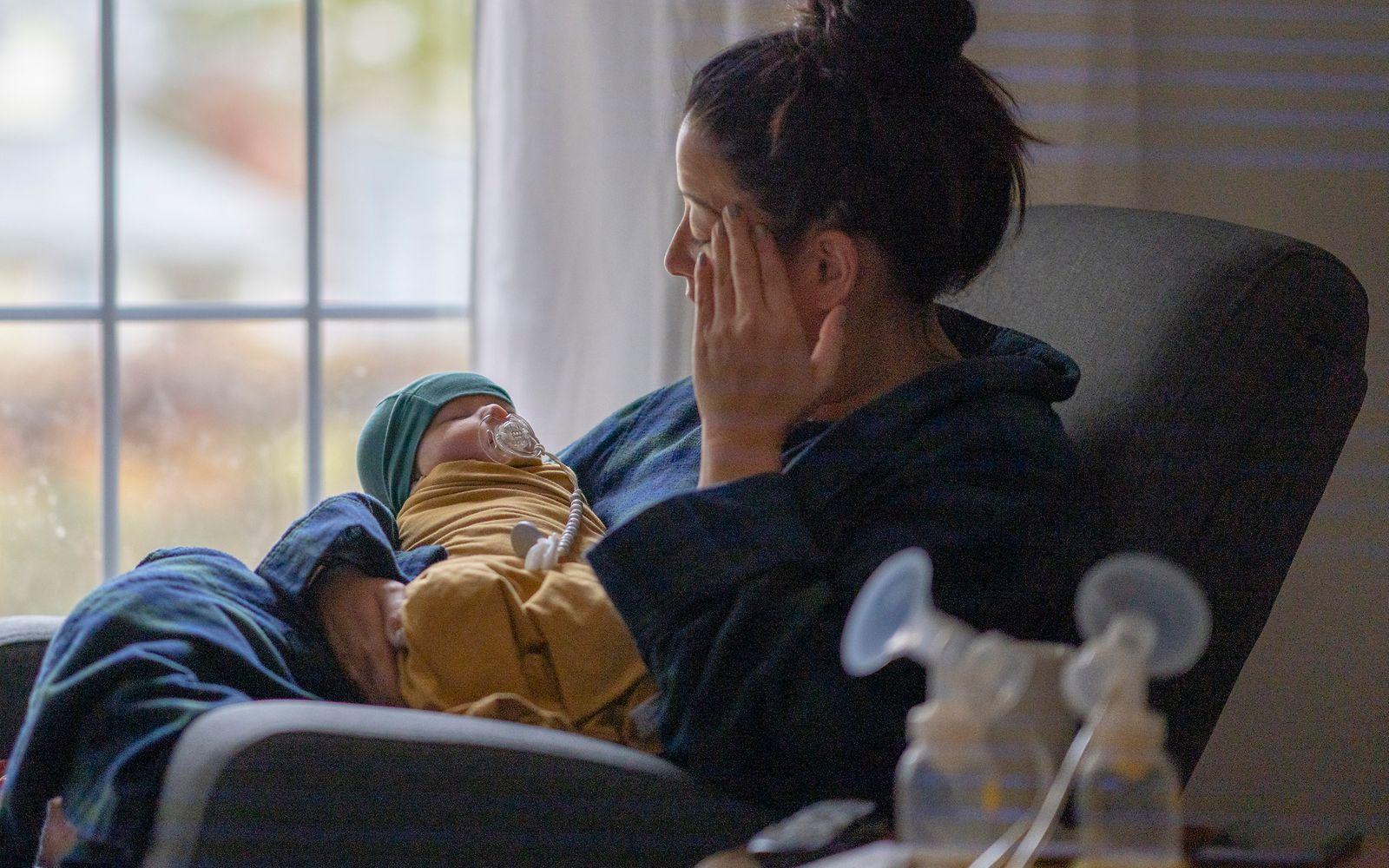 Symbolbild Smart-e-Moms: eine Frau mit Wochenbettdepressionen hält ihr Baby