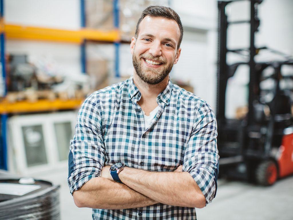 Image: Worker with plaid shirt smiles at the camera