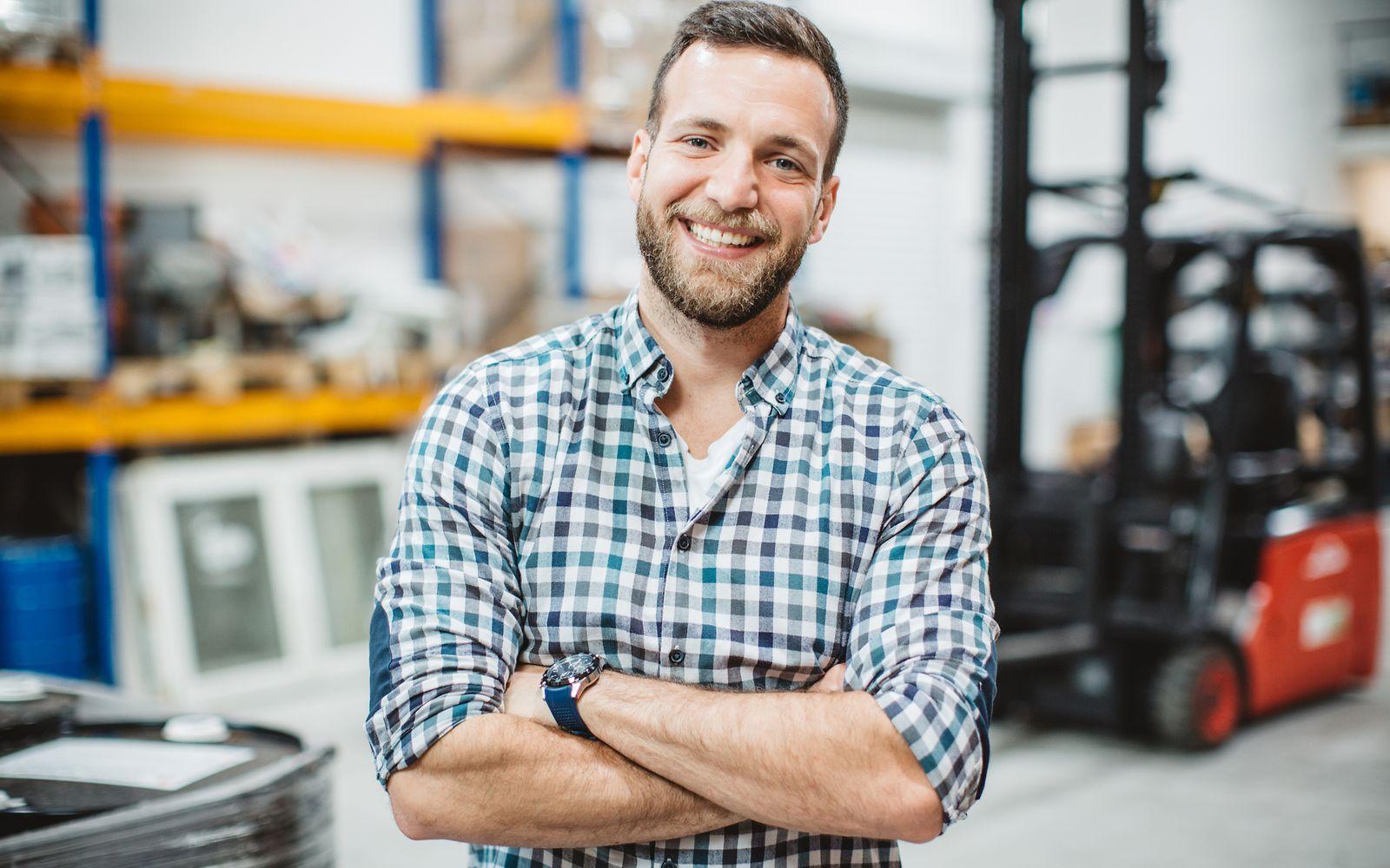 Image: Worker with plaid shirt smiles at the camera