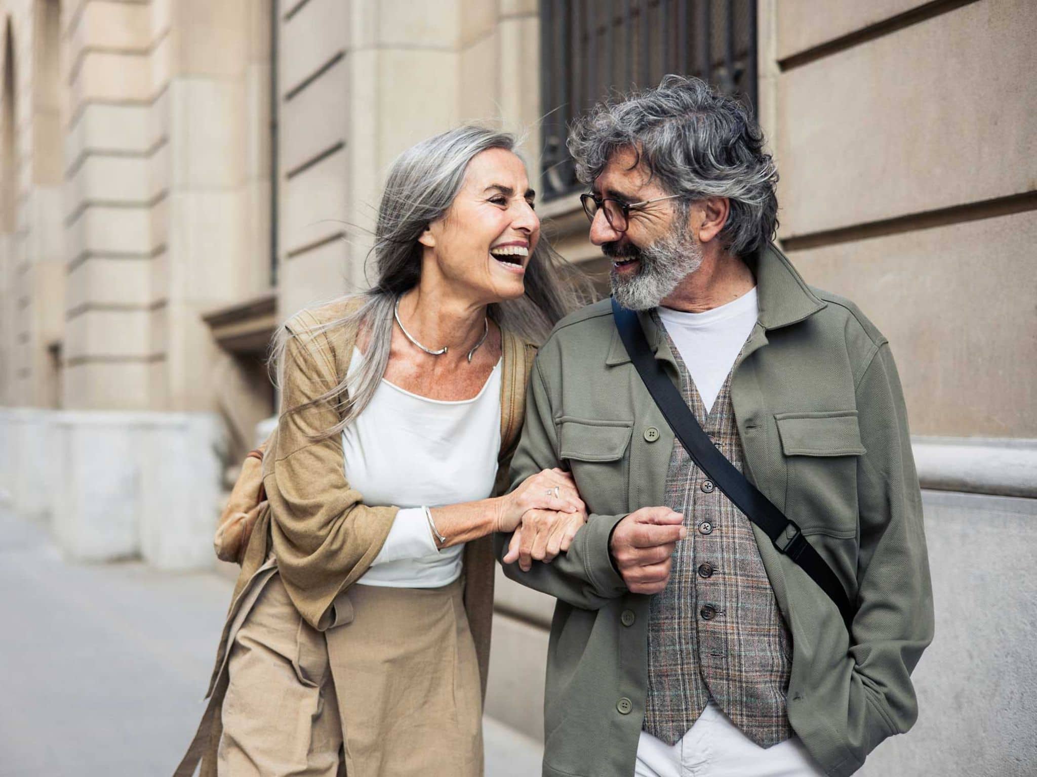 Ein älteres Paar spaziert lachend durch die Stadt