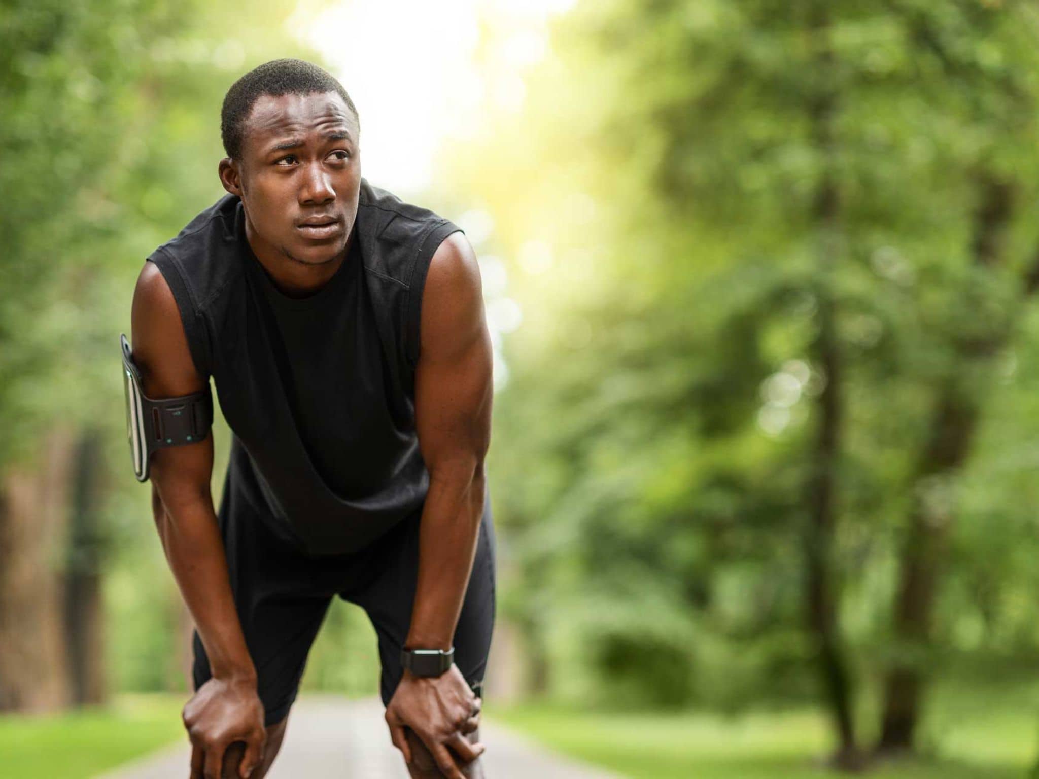 Herzfrequenzvariabilität: Junger Mann hält erschöpft im Lauf inne
