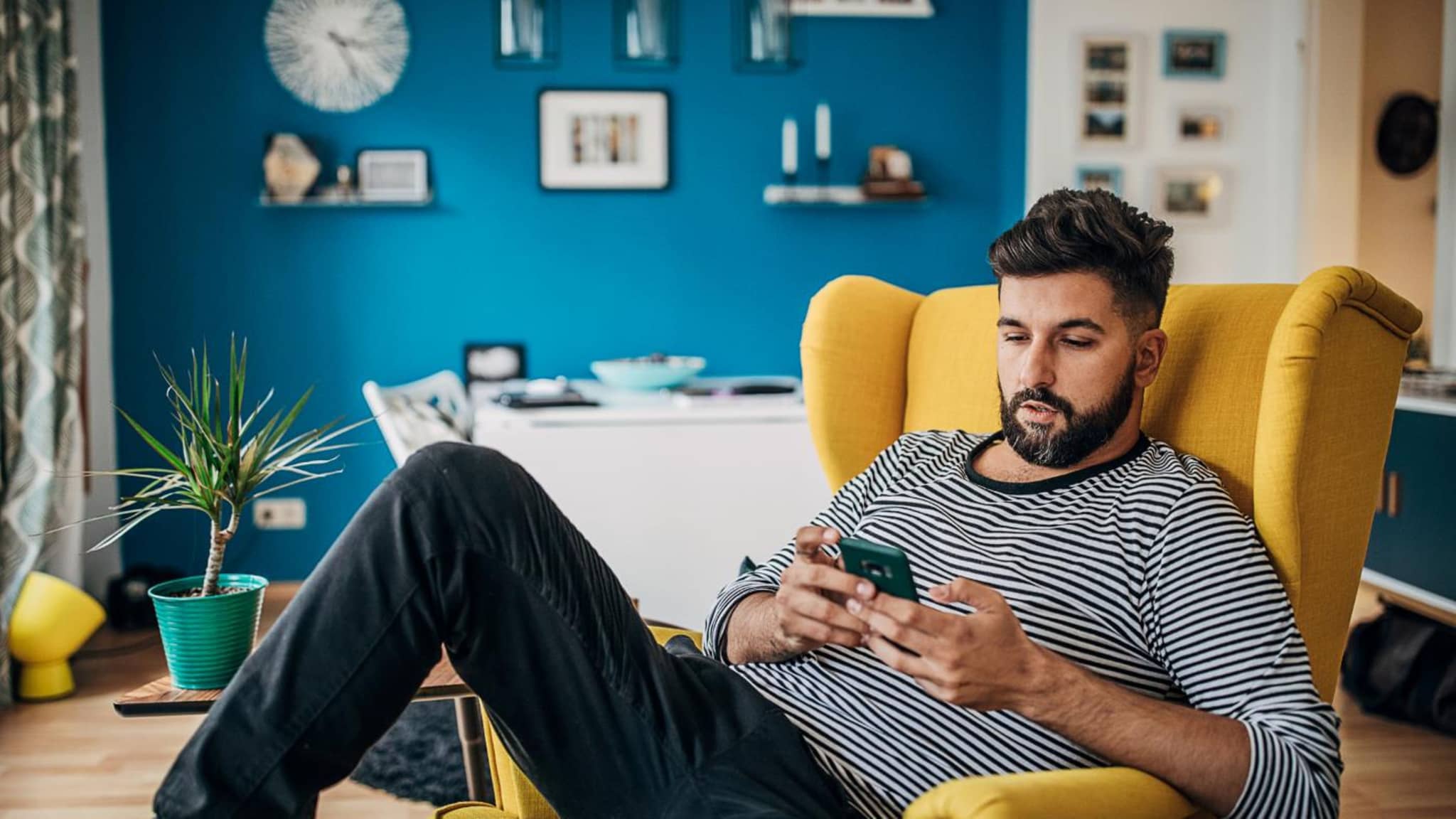 DAK App: Man is sitting in a chair and casually using his smartphone.