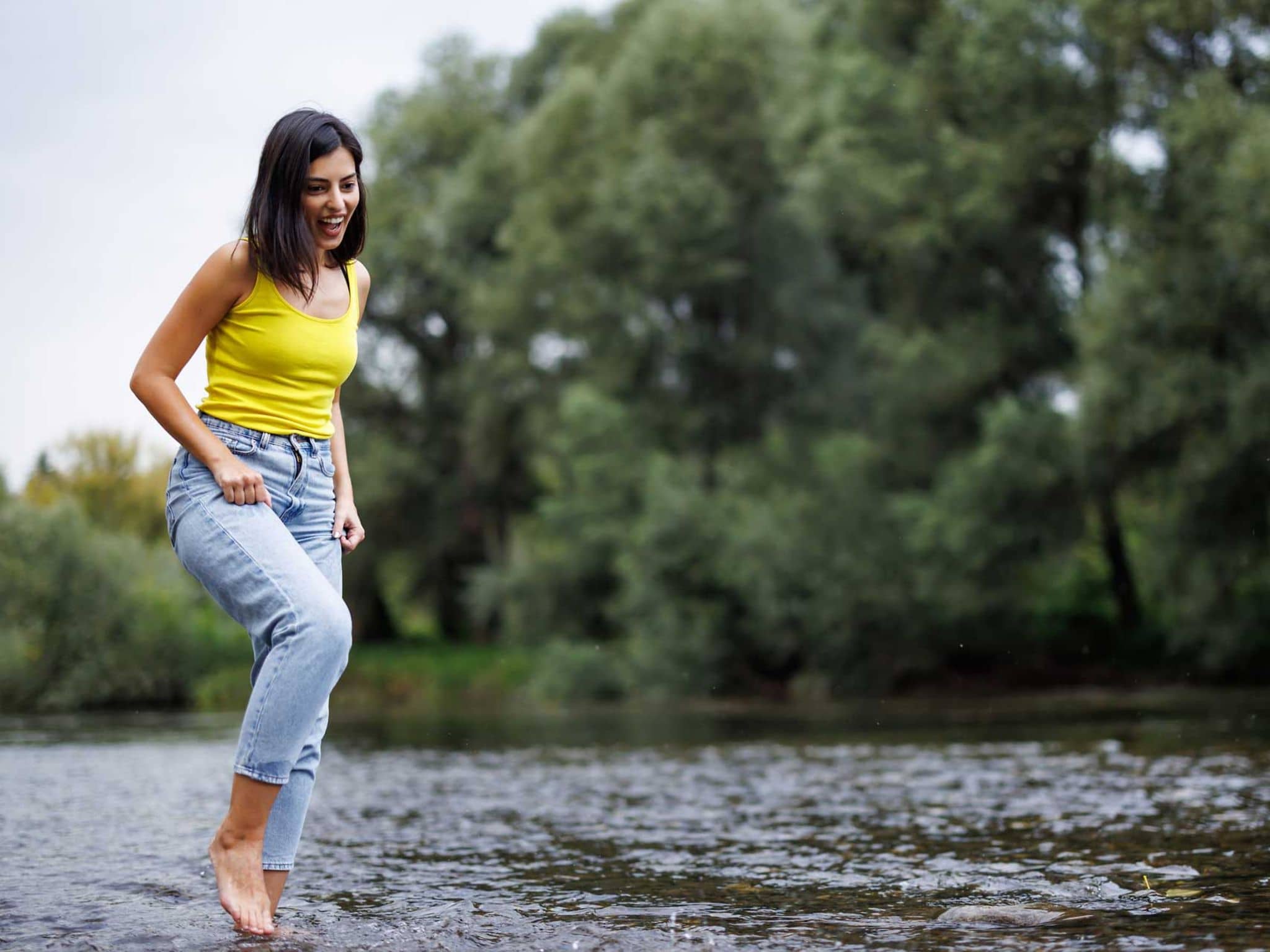 Junge Frau beim Kneippen in Natursee