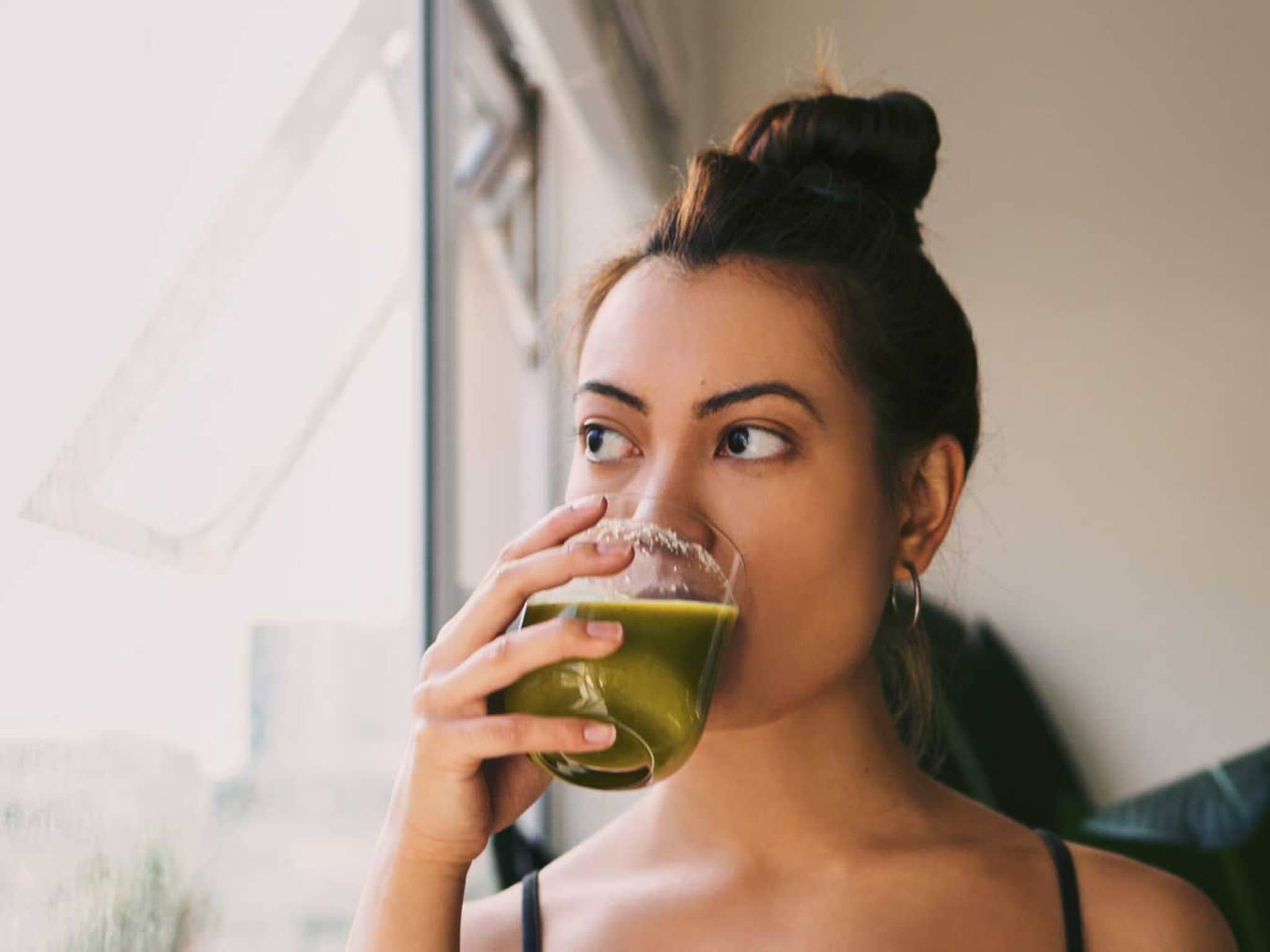 Junge Frau trinkt Selleriesaft aus einem Glas