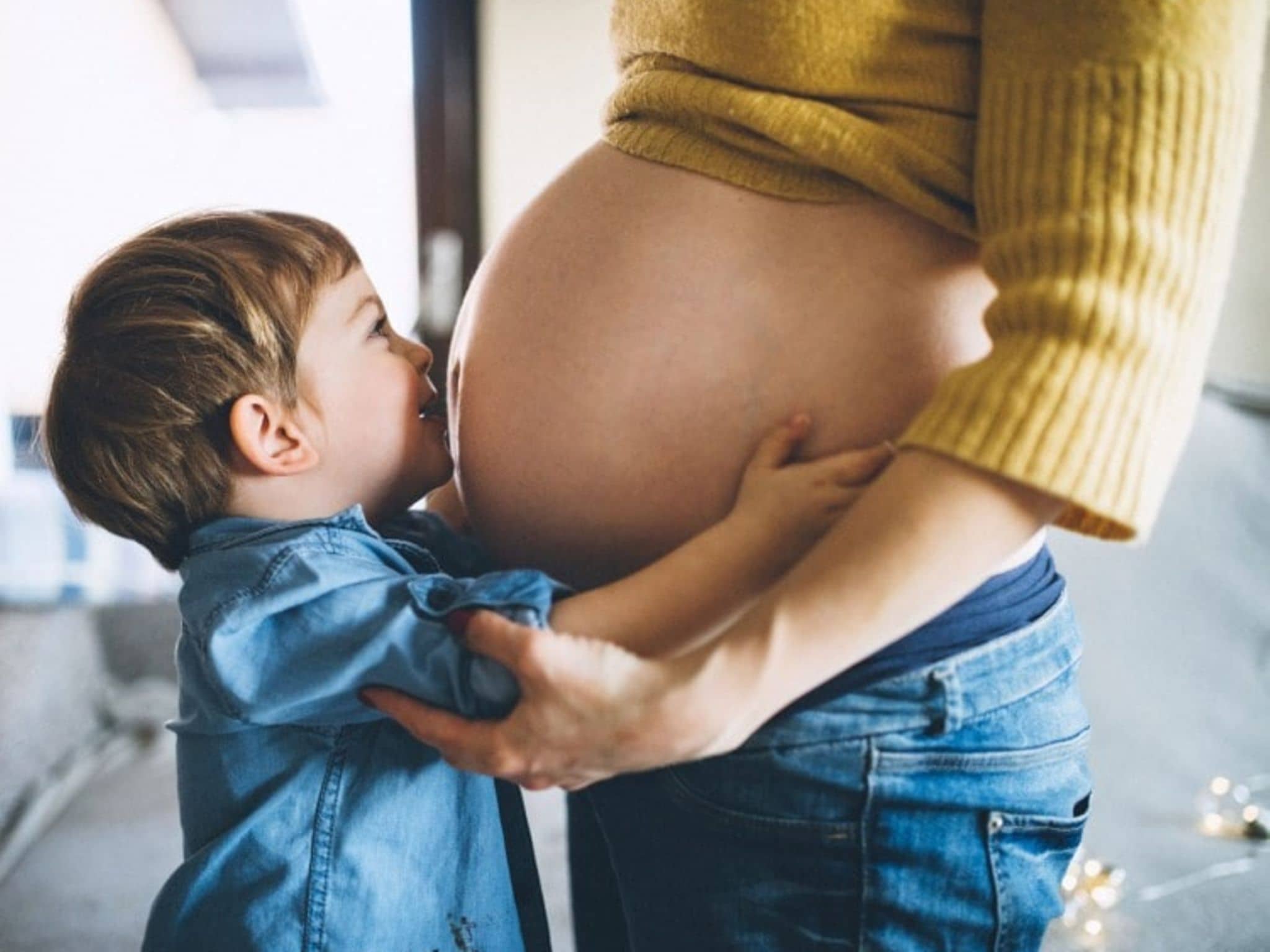 Rhesusfaktor-Untersuchung: Junge küsst Babybauch.