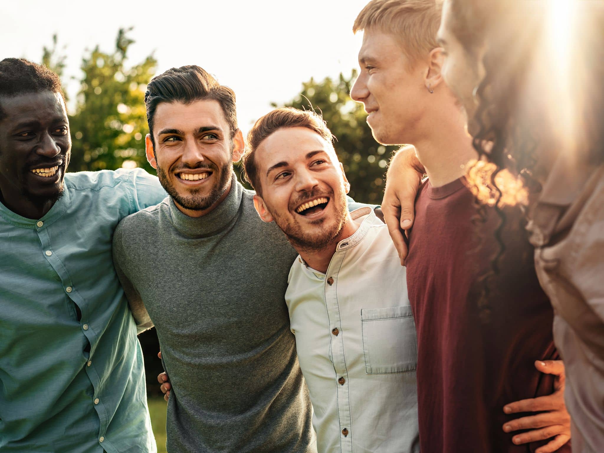 Toxic Positivity: Eine Gruppe junger Männer steht lachendend zusammen