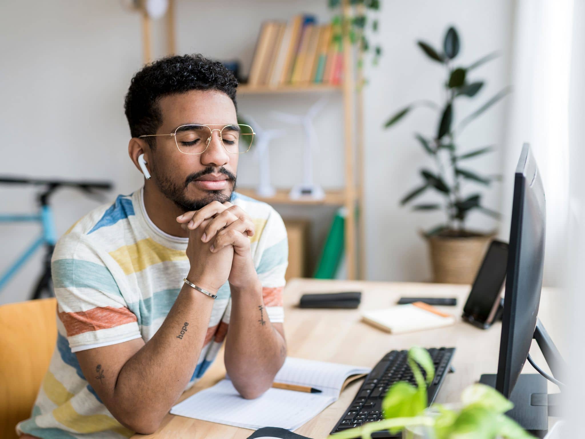 Achtsamkeit im Alltag: Ein Mann sitzt an einem Schreibtisch und entspannt