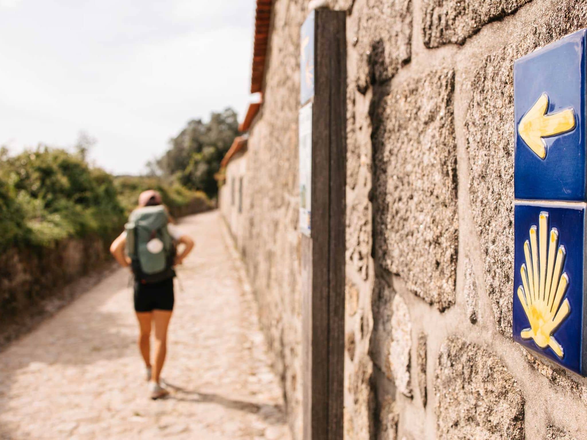 Frau folgt den Schildern auf dem Pilgerweg Santiago de Compostela